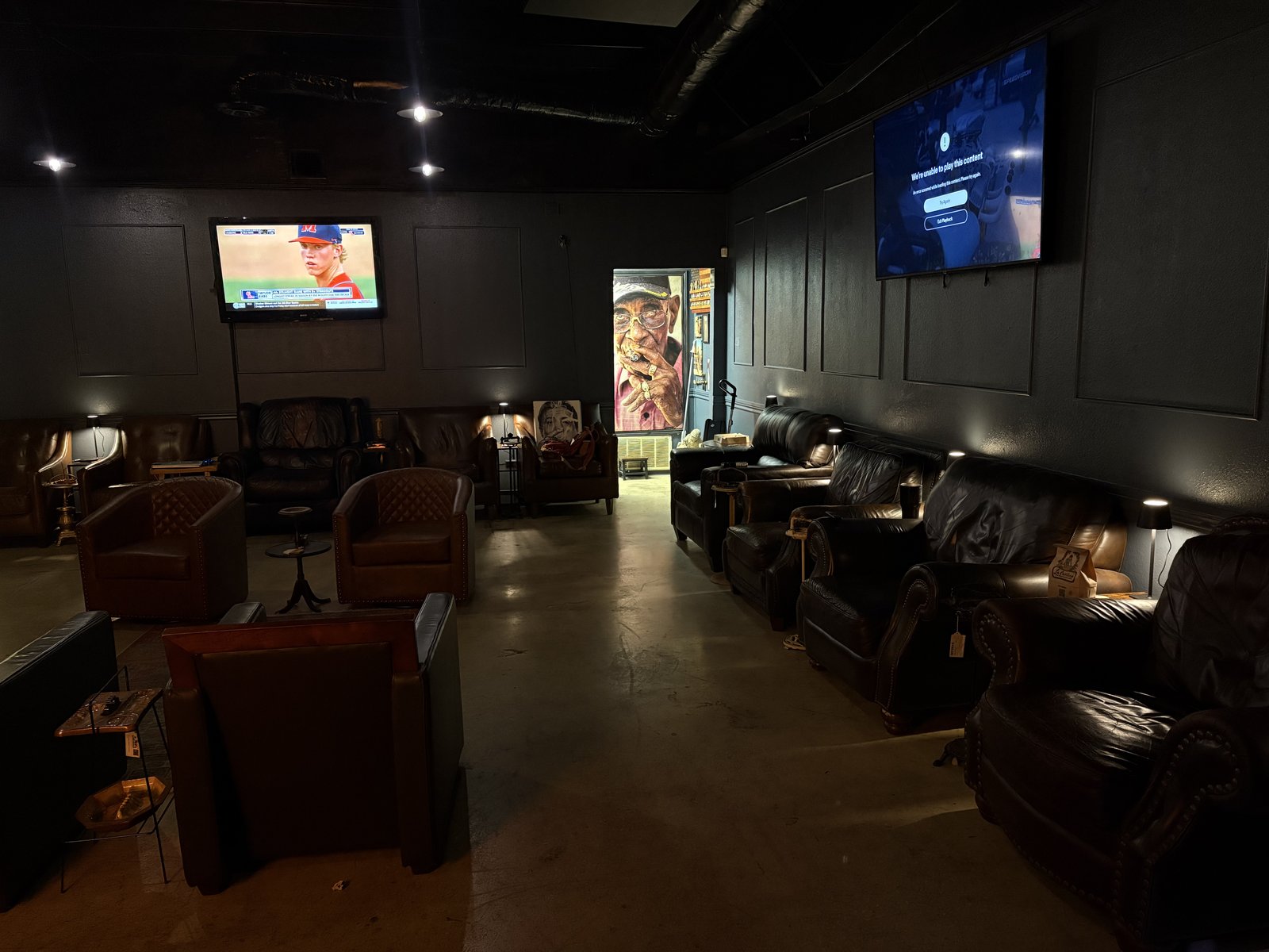 Leather lounge seating and TVs inside BBQ City Cigars